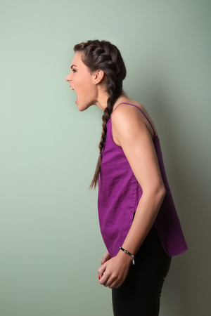 Portrait of aggressive young woman on color backgroundの写真素材