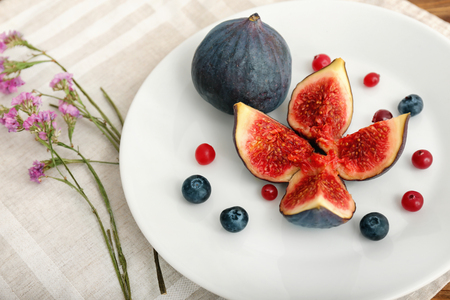 Fresh ripe figs with berries on plateの写真素材