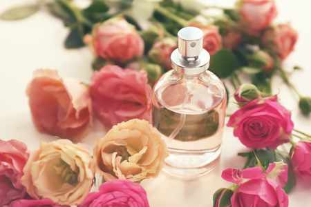 Bottle of perfume with beautiful flowers on white tableの写真素材