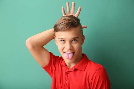 Funny portrait of teenage boy on color backgroundの写真素材