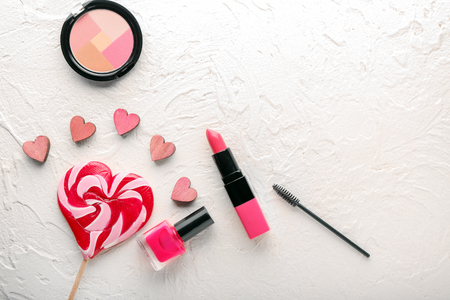 Set of cosmetics with heart shaped lollipop on white backgroundの写真素材