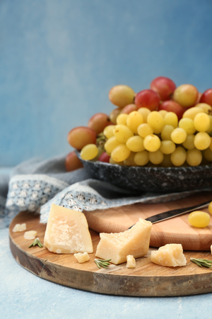 Plate with ripe juicy grapes and cheese on wooden boardsの写真素材