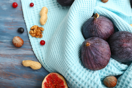 Fresh ripe figs with napkin on color wooden tableの写真素材