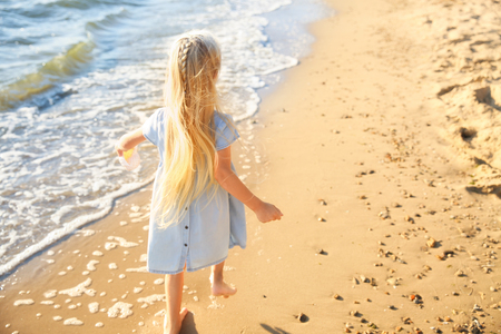 Cute little girl running on sea beachの写真素材