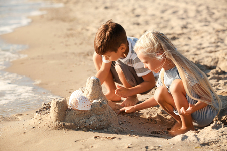 Cute little children building sand castle on sea beachの写真素材