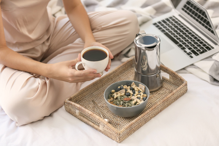 Young woman having delicious breakfast on bedの写真素材