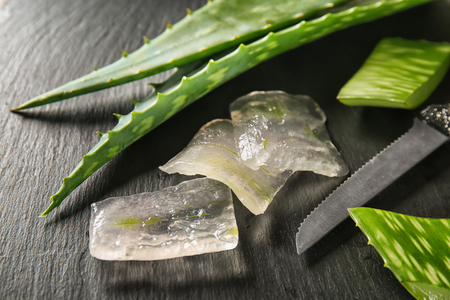 Cut Aloe vera with knife on dark tableの写真素材