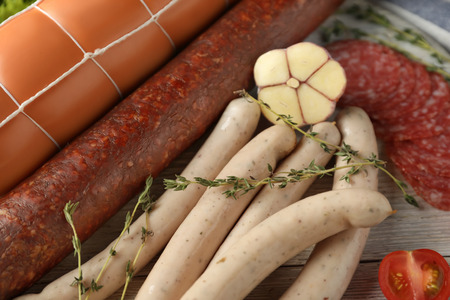 Different kinds of sausages on wooden board, closeupの写真素材