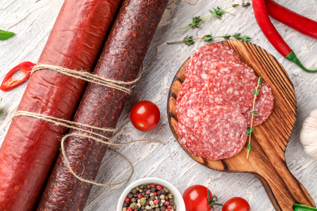 Delicious smoked sausages with spices on light tableの写真素材