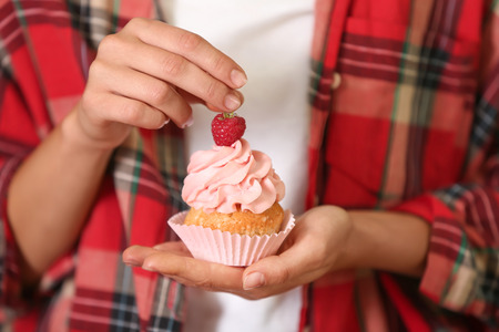 Woman holding delicious cupcake, closeupの写真素材