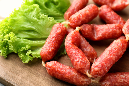 Delicious smoked sausages on wooden board, closeupの写真素材