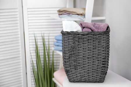 Laundry basket with dirty towels on shelfの写真素材