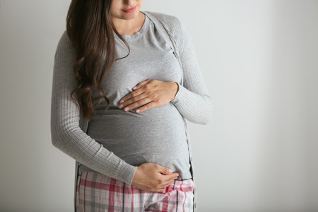 Beautiful pregnant woman on grey background