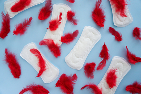 Menstrual pads with red feathers on color backgroundの写真素材