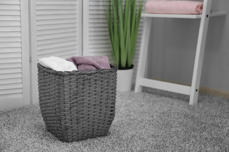Laundry basket with dirty towels on floor in roomの写真素材