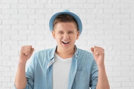 Portrait of handsome successful young man against white brick wallの写真素材