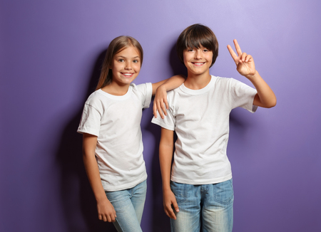 Cute little children in t-shirts on color backgroundの写真素材