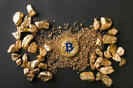 Bitcoin and gold nuggets on black backgroundの写真素材