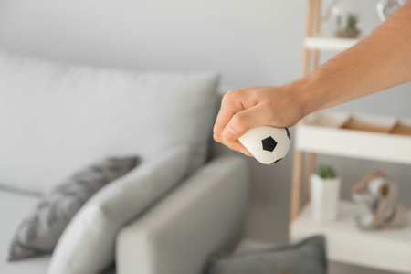 Man squeezing stress ball at home