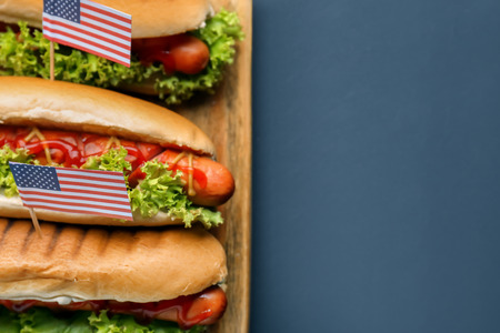 Tasty hot dogs with American flags on boardの写真素材