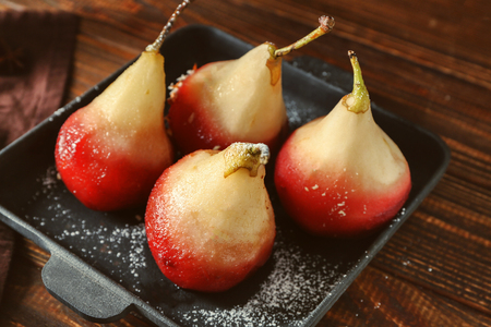 Delicious poached pears in red wine on panの写真素材