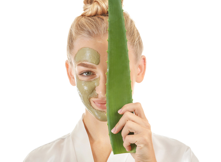 Beautiful young woman with facial mask containing aloe vera extract, on white backgroundの写真素材