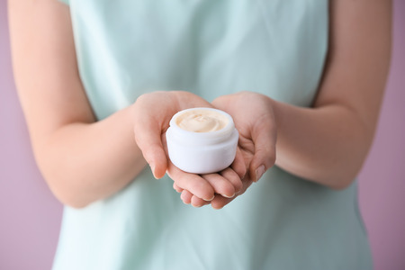 Woman holding jar of body cream, closeupの写真素材