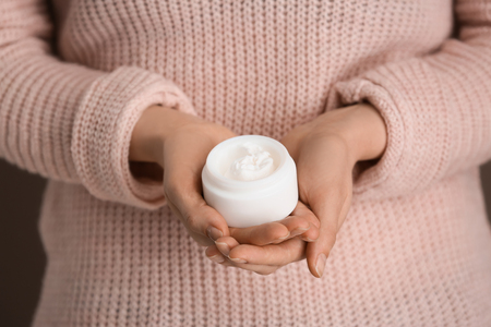 Woman holding jar of body cream, closeupの写真素材