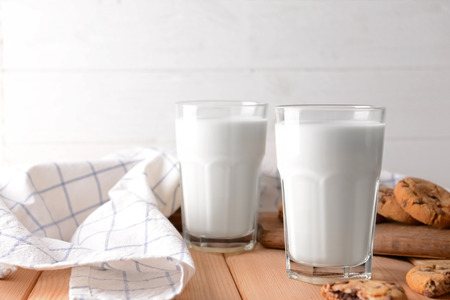 Glasses of tasty milk and cookies on wooden tableの写真素材