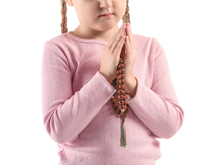 Little girl with beads praying on white backgroundの写真素材