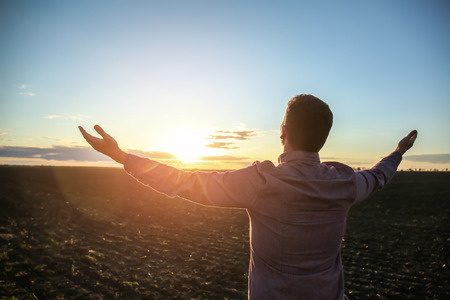 Religious man praying outdoors at sunsetの写真素材
