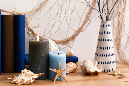 Books, burning candles and seashells on tableの写真素材
