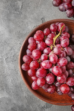 Plate with sweet grapes on grunge tableの写真素材