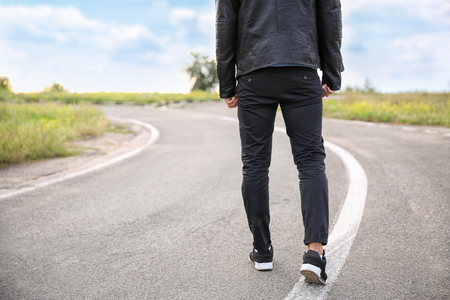 Young man going along road. Concept of choiceの写真素材