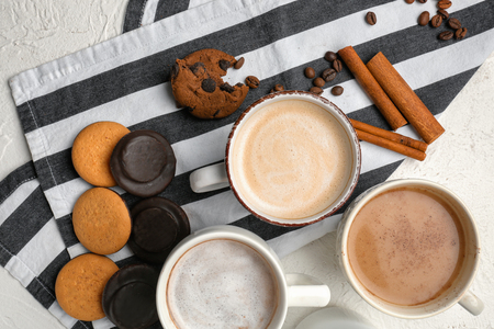 Many cups with tasty aromatic coffee and cookies on white tableの写真素材