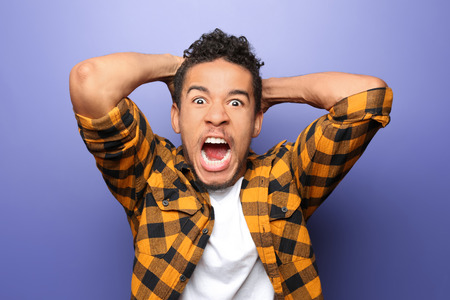 Portrait of aggressive African-American man on color backgroundの写真素材