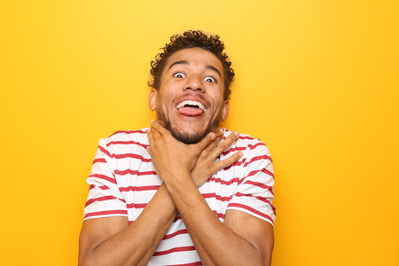 Portrait of crazy African-American man on color backgroundの写真素材