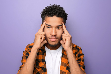 Portrait of thoughtful African-American man on color background