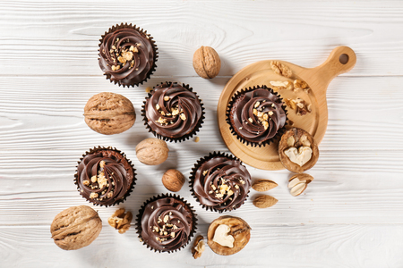 Composition with chocolate cupcakes and walnuts on wooden tableの写真素材