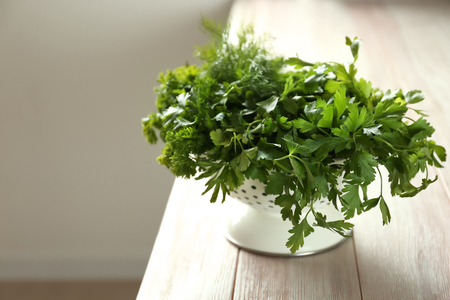Colander with fresh aromatic herbs on wooden tableの写真素材