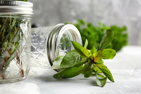 Jar with fresh aromatic rosemary on light tableの写真素材