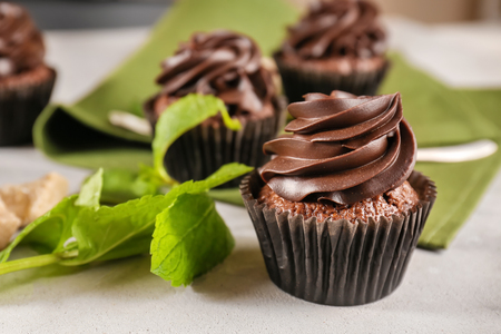 Tasty chocolate cupcake with mint on grey table, closeupの写真素材