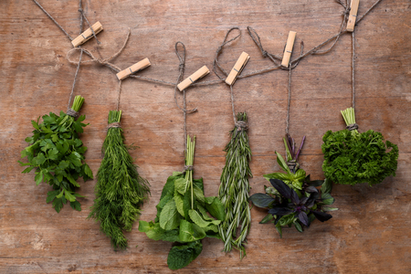 Bunches of different fresh herbs on wooden backgroundの写真素材