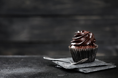 Delicious chocolate cupcake on dark tableの写真素材