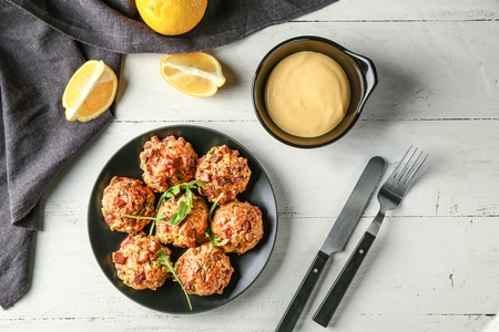 Plate with tasty sausage balls and bowl of cheese sauce on table, top viewの写真素材