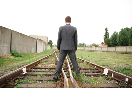 Businessman standing on railway tracks. Concept of choiceの写真素材