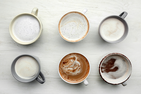 Many cups with tasty aromatic coffee on white tableの写真素材
