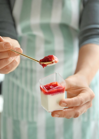 Woman eating tasty strawberry panna cotta, closeupの写真素材