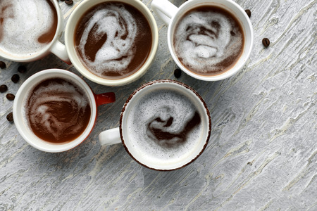 Many cups with tasty aromatic coffee on light tableの写真素材