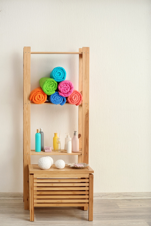 Rolled terry towels and cosmetics on shelvesの写真素材